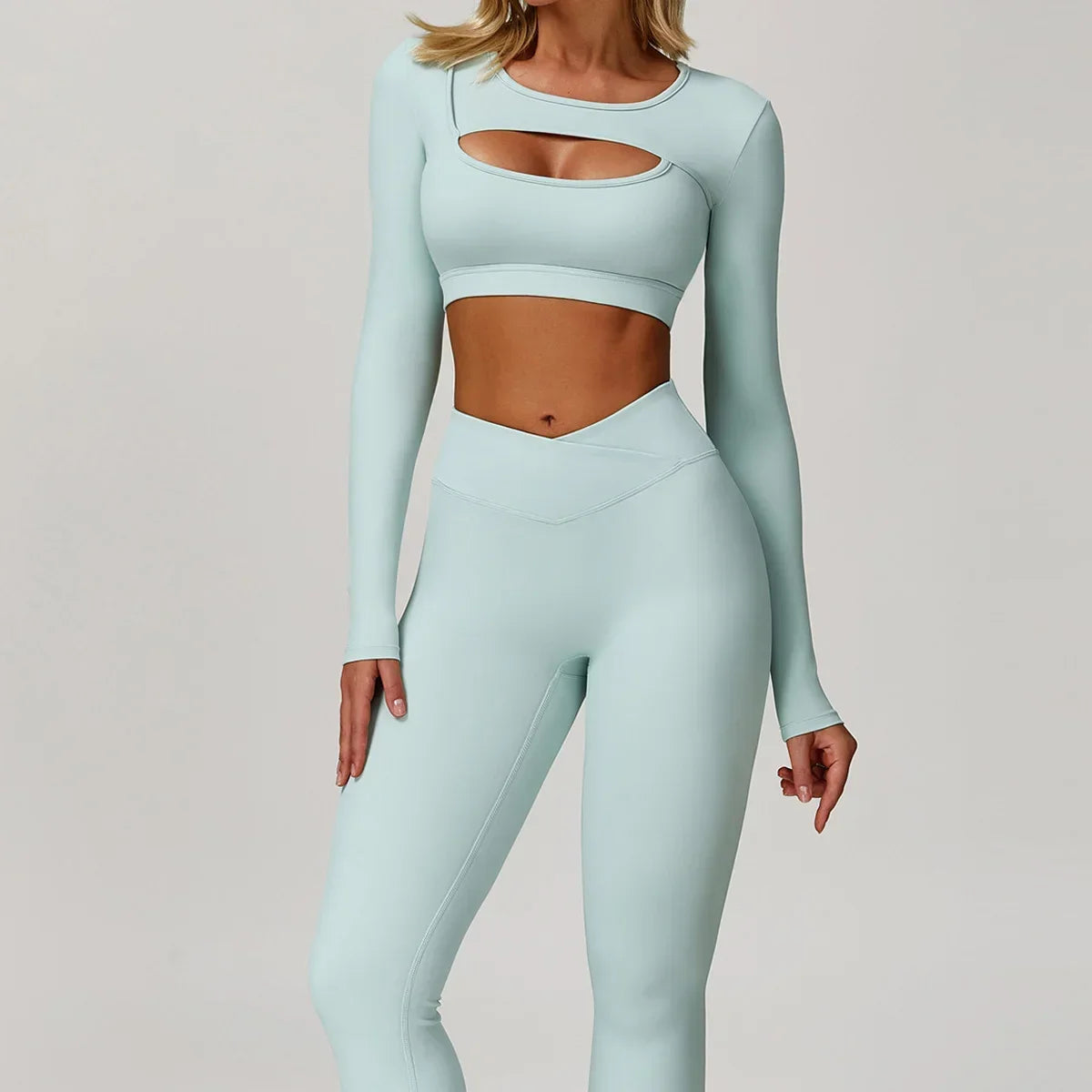 Light blue athletic outfit with long-sleeve top and leggings on a plain background