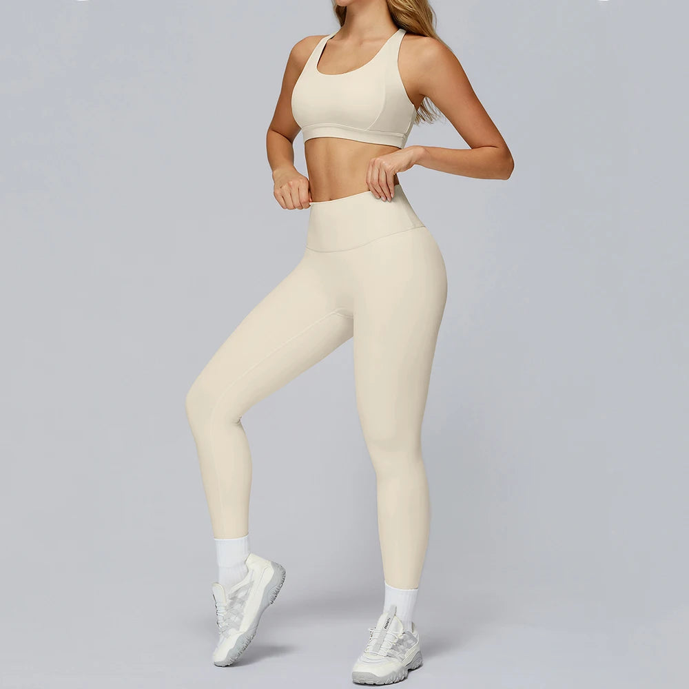 Person wearing a beige sports bra and leggings set on a gray background
