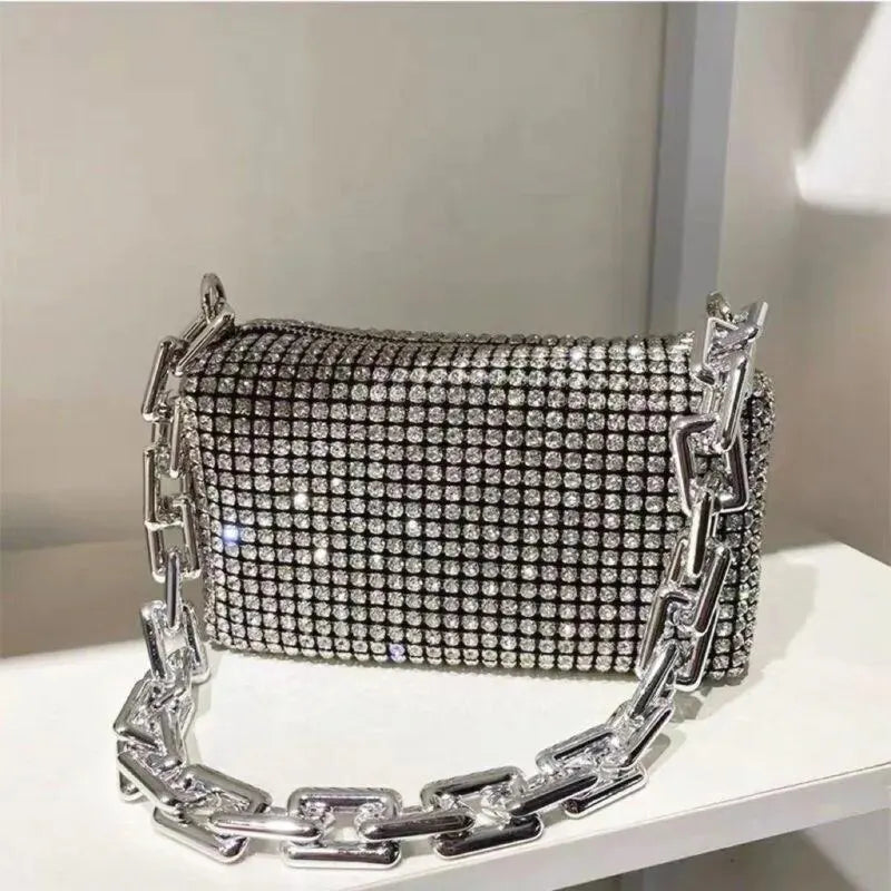 Silver clutch bag with chain detail on a white surface
