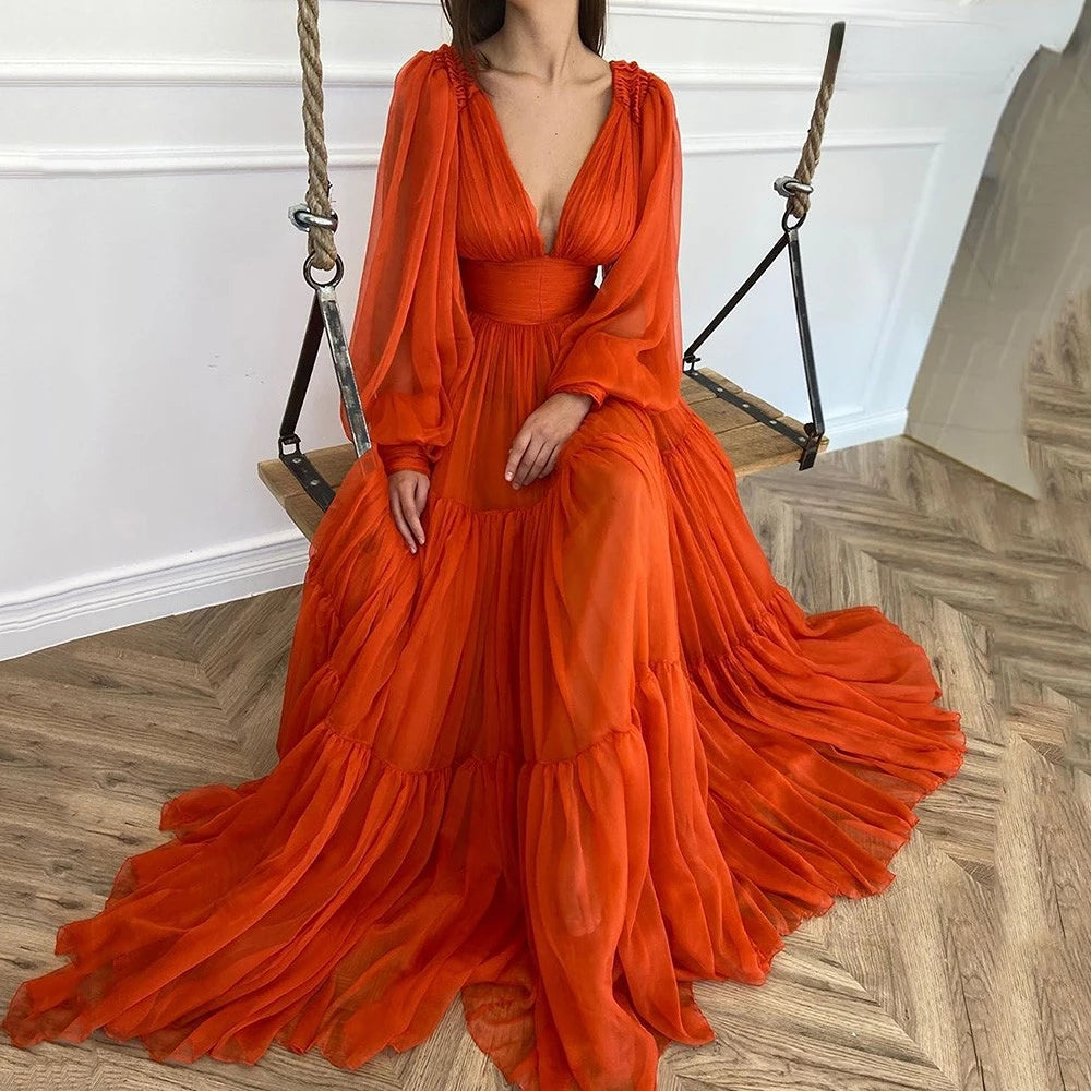 Woman in an orange dress sitting on a wooden swing indoors.