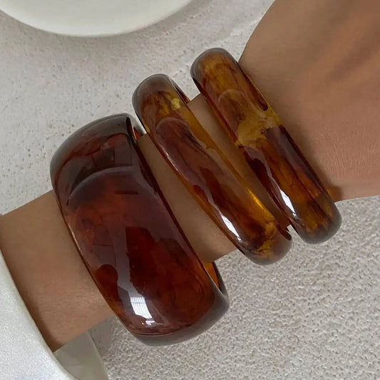 Two tortoiseshell bangles on a neutral background