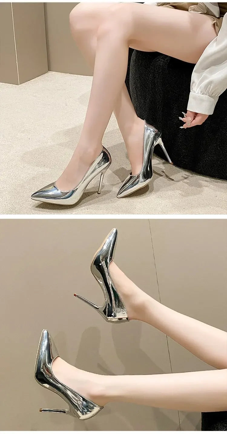 Silver high-heeled shoes worn by a person sitting on a chair.